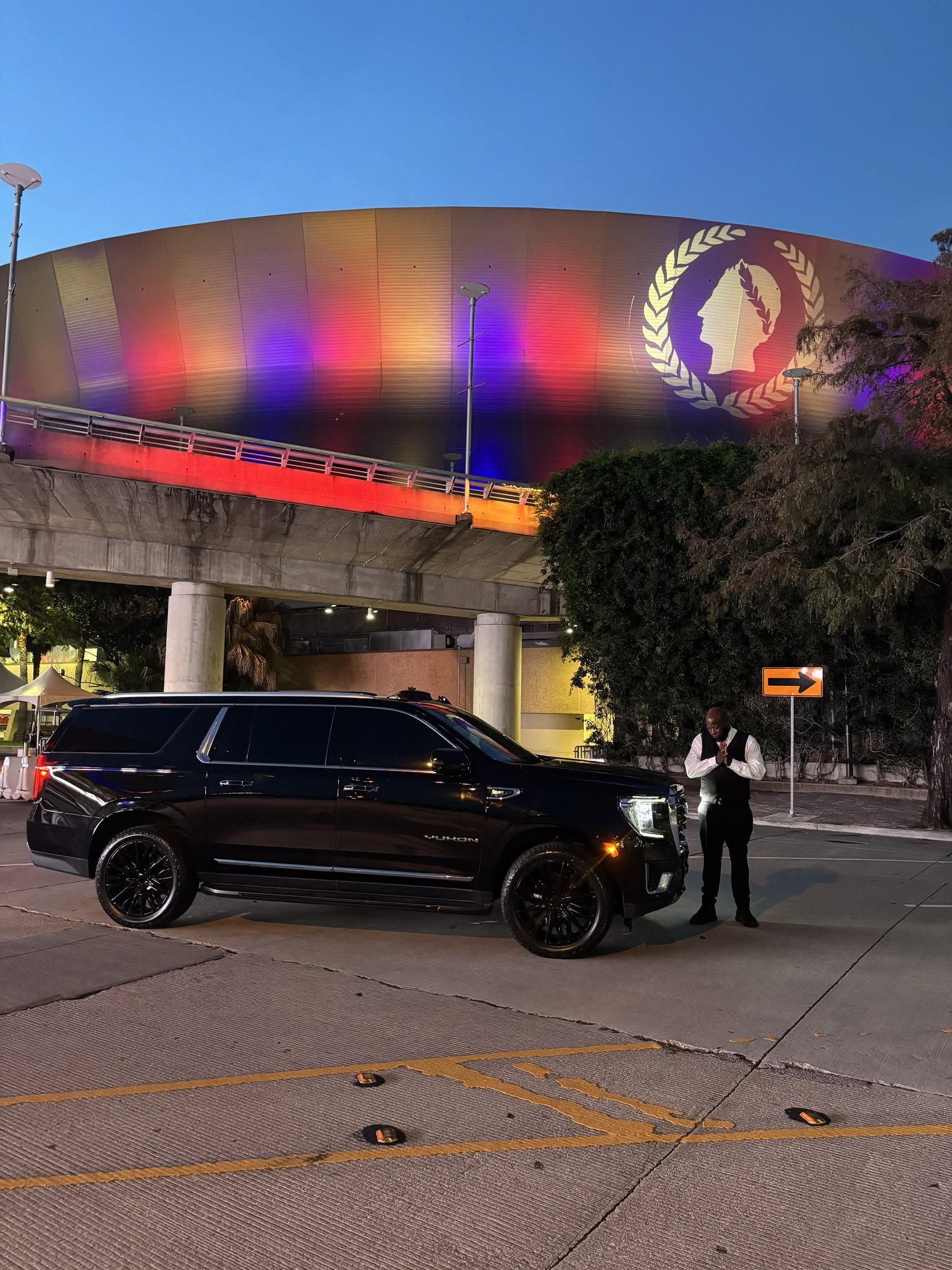 Load Up and Ride chauffeur beside a black luxury SUV with the Caesars Superdome in the background